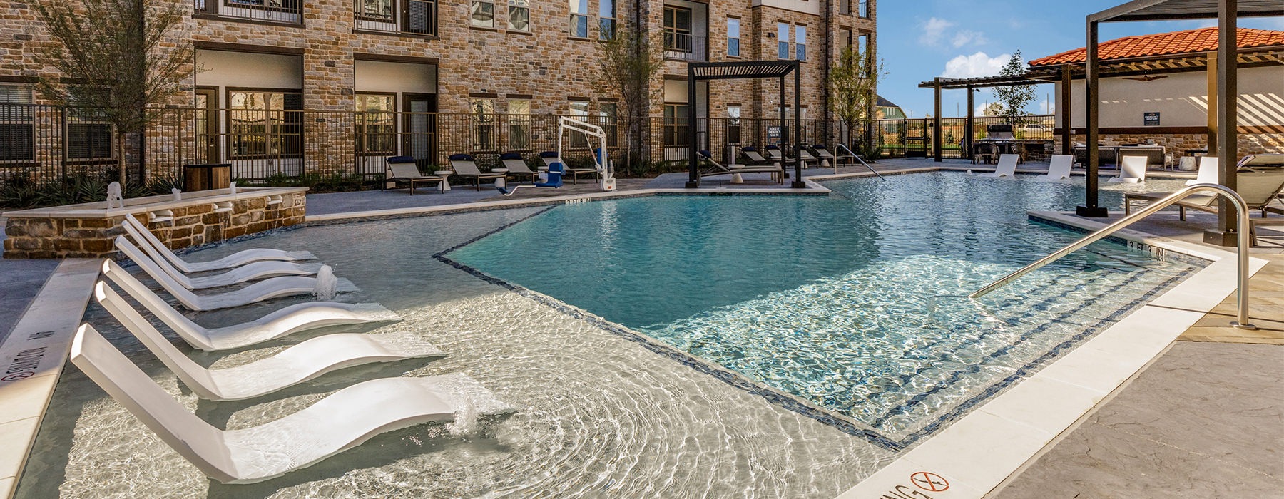 Large sparkling pool with large pool deck and lounge chairs