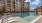 Three-Bedroom Apartments in Grand Prairie, TX - Jefferson Cove - Resort-Style Pool with a Sundeck, Cabanas, Lounge Chairs, and a Water Fountain